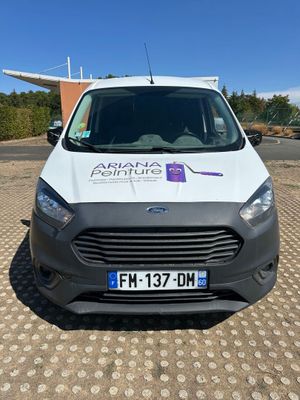 the front of a white van parked in a parking lot