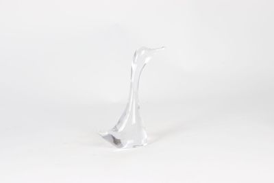 a glass sculpture of a bird on a white surface