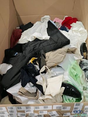 une boîte en carton remplie de vêtements et une paire de ciseaux