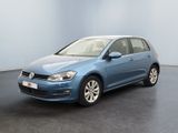 La Volkswagen Golf bleue est garée dans une grande pièce.