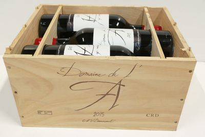une caisse en bois contenant trois bouteilles de vin