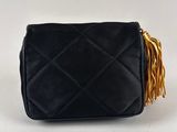 a black quilted purse with tassels on the handle