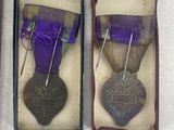 three medals are in a box on a white surface