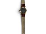 an image of a watch on a white surface with a brown strap