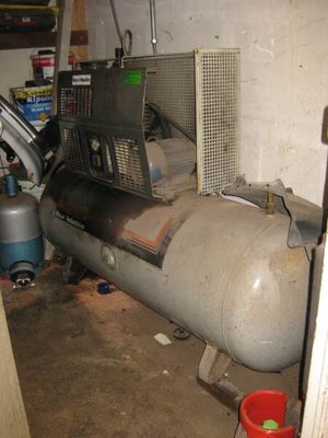 un grand réservoir posé dans un garage, à côté d'un climatiseur