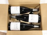 three bottles of wine are in a cardboard box on a table