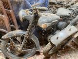 une moto sale qui est garée dans la poussière