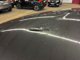 many cars parked in a parking lot with one car missing