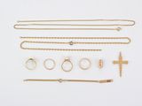 an assortment of gold jewellery including rings, bracelets, and a cross