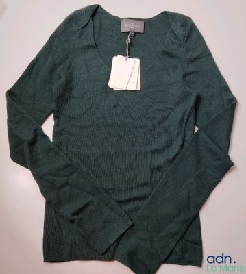 une photo d'un pull vert avec une étiquette dessus