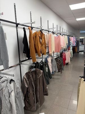 a lot of clothes hanging on a rack in a store