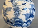 un vase bleu et blanc orné d'un paysage