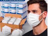 un homme portant un masque à côté d'une boîte de masques