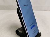 a close up of a cell phone on a stand on a white surface