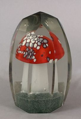 a glass vase with a red and white mushroom inside of it