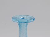 a blue glass vase with a flower on top of it