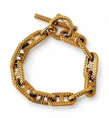 a close up of a gold bracelet on a white background