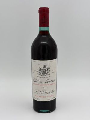 a bottle of red wine sitting on top of a white table