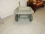 a wheelbarrow in a room with a couch in the background