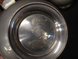 a silver tea pot with a lid on a table