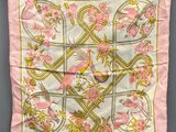 a pink silk scarf with birds and flowers on it