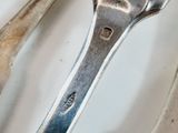 two spoons and a fork on a white plate