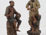 deux figurines représentant un homme et une femme assis sur un rocher