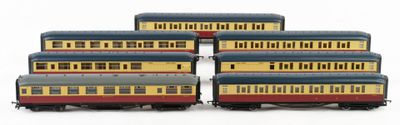 six toy train cars are lined up on a white surface