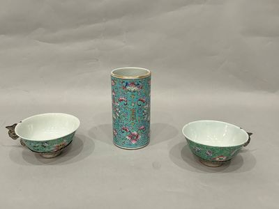 two cups and a saucer sitting on a table next to each other