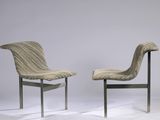 pair of modern chairs with curved backrests on a white background