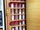une armoire en bois contenant des épices et des bocaux