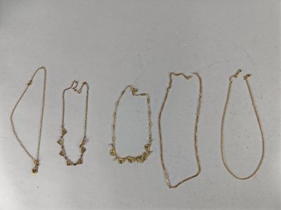 four different types of gold necklaces on a white surface