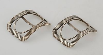 a pair of silver buckles on a white background