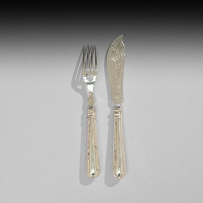deux fourchettes et un couteau sur une table blanche
