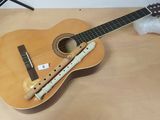 a wooden guitar and a flute on a table