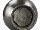 a black vase that has a hole in the middle of it