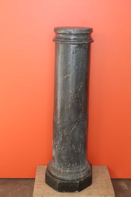 an image of a black marble pedestal with a red wall in the background