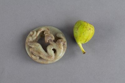 une figurine représentant une femme et une poire posées sur une table