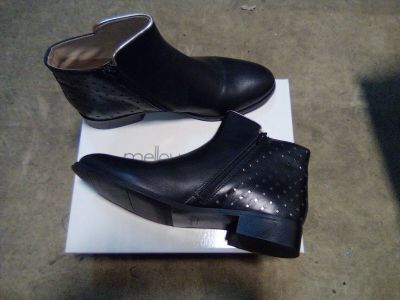 pair of black leather ankle boots sitting on top of a white box