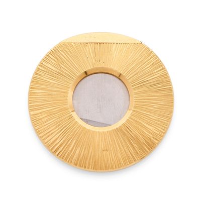 une image représentant un miroir circulaire doré accroché à un mur blanc