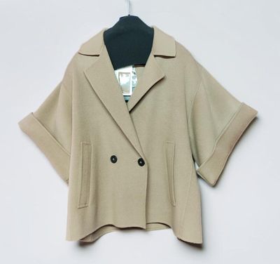 a close up of a jacket on a hanger on a white wall
