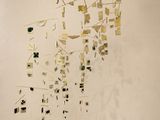 une sculpture composée de carrés dorés et noirs sur un mur blanc