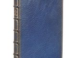un vieux livre à la couverture bleue posé sur une surface blanche