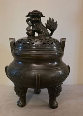 une image représentant un brûle-parfum en bronze surmonté d'un oiseau