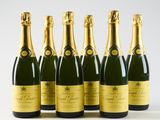 six bottles of champagne are lined up in a row