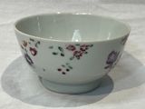 a white bowl with flowers on it sitting on a table