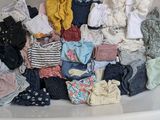 une baignoire remplie de plein de vêtements et d'un ours en peluche