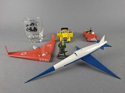 un petit avion en jouet posé à côté d'un verre de vin