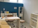 une pièce équipée d'un bureau, d'une chaise, d'étagères et d'un réfrigérateur