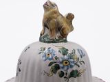 an image of a cat sitting on top of a cake plate